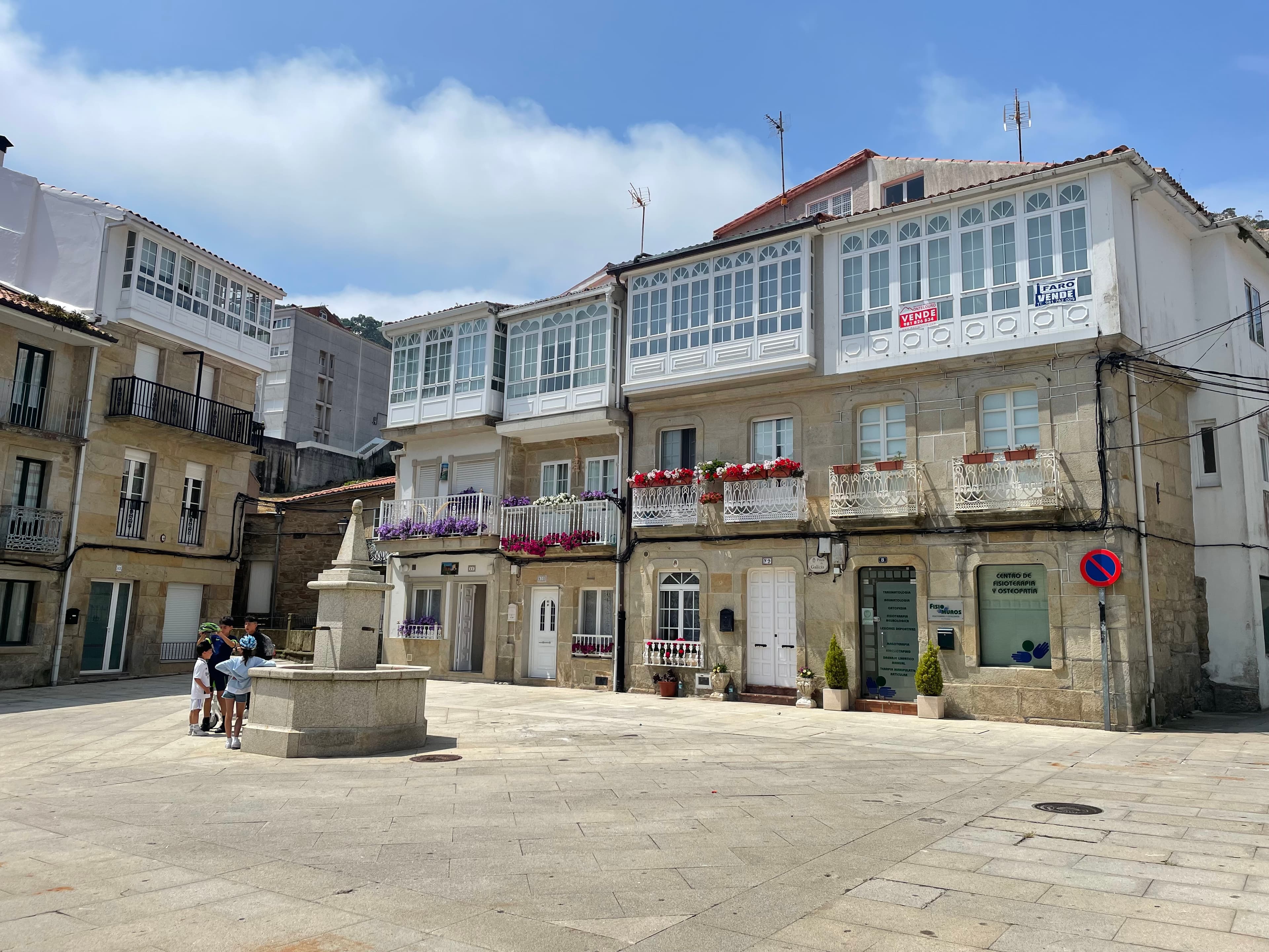 Traditional Galician glazed balconies in a village square in Muros